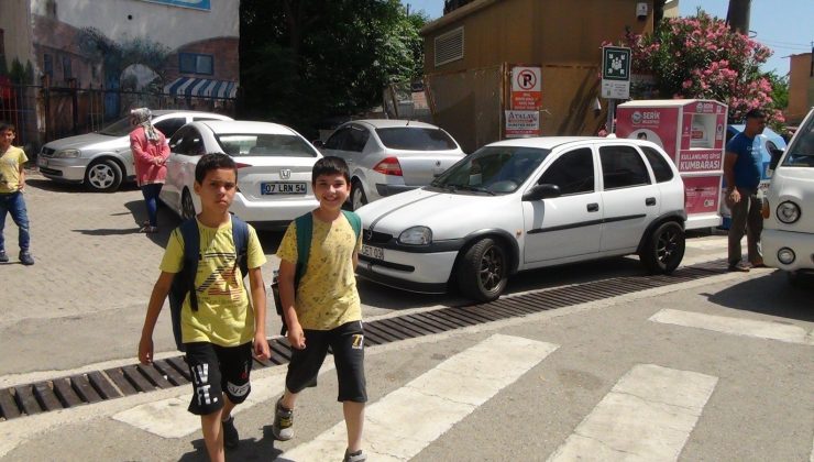 Okul çıkışında trafikte öğrencileri korumak için mücadele ediyor